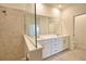 Bathroom featuring double sinks, large mirror, and tiled shower with glass partition at 17715 Boracay Ct # 202, Venice, FL 34293