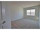 Sunlit bedroom with neutral walls, carpet, and a window showing the neighborhood at 17715 Boracay Ct # 202, Venice, FL 34293