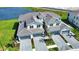 A view of two-story townhomes featuring gray roofs and driveways, with attached garages and well-manicured lawns at 17715 Boracay Ct # 202, Venice, FL 34293