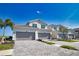 Modern townhomes with neat garages and landscaped front yards on a sunny day at 17715 Boracay Ct # 202, Venice, FL 34293