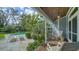Charming back porch with rocking chairs overlooking the lush garden and pool area at 1774 Cherokee Dr, Sarasota, FL 34239