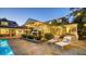 Tranquil backyard oasis with a pool, lounge chairs, outdoor kitchen, and lush landscaping for ultimate relaxation at 1774 Cherokee Dr, Sarasota, FL 34239