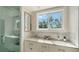 Bright bathroom with double vanity, marble backsplash, and a glass shower at 1774 Cherokee Dr, Sarasota, FL 34239