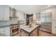 Well-appointed kitchen with stainless steel appliances, white cabinetry, marble countertops, and a stylish island at 1774 Cherokee Dr, Sarasota, FL 34239