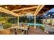 Elegant outdoor dining area in a covered gazebo with a ceiling fan and views of the pool and lush landscaping at 1774 Cherokee Dr, Sarasota, FL 34239