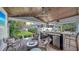 Covered outdoor kitchen with bar seating and a cozy lounge area at 1774 Cherokee Dr, Sarasota, FL 34239