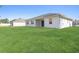 Home's backyard features a manicured lawn and covered lanai at 18100 Poston Ave, Port Charlotte, FL 33948