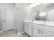 Modern bathroom with double sink vanity, large mirror, and tiled shower at 18100 Poston Ave, Port Charlotte, FL 33948