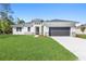 Charming single-story home featuring a well-manicured lawn and a neutral color palette with decorative stone accents at 18100 Poston Ave, Port Charlotte, FL 33948