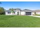 Charming single-story home featuring a well-manicured lawn and a neutral color palette with decorative stone accents at 18100 Poston Ave, Port Charlotte, FL 33948