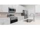 Modern kitchen with stainless steel appliances, white cabinets, and quartz countertops at 18100 Poston Ave, Port Charlotte, FL 33948
