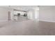 Open-concept space with gray wood-look tile, featuring a modern kitchen with white cabinets at 18100 Poston Ave, Port Charlotte, FL 33948