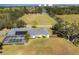 Aerial view of a home with solar panels and a covered pool on a large grassy lot with white fencing at 2005 21St W St, Palmetto, FL 34221