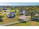 Aerial view of a white home with black shutters, surrounded by green lawns, trees, and a white fence at 2005 21St W St, Palmetto, FL 34221