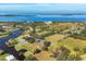 An aerial view reveals a home with a pool amidst lush greenery, ponds, and a sprawling landscape by the bay at 2005 21St W St, Palmetto, FL 34221