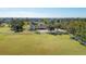 Wide shot of a large property with a well-maintained lawn, white fencing, and mature trees providing shade at 2005 21St W St, Palmetto, FL 34221