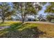 White brick home with mature trees, a circular driveway, an attached garage and lush green lawn at 2005 21St W St, Palmetto, FL 34221