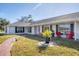 Charming single-story home featuring a well-manicured lawn, brick walkway, and inviting front porch with red chairs at 2005 21St W St, Palmetto, FL 34221