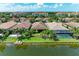 Aerial view of backyard oasis featuring dock, and community pool, along the lake at 204 Maraviya Blvd, Nokomis, FL 34275