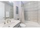 Well-lit bathroom featuring gray tiling around the bath/shower and a large gray vanity at 204 Maraviya Blvd, Nokomis, FL 34275