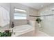 Spa-like bathroom with a soaking tub, glass-enclosed shower, and tiled walls for a luxurious feel at 204 Maraviya Blvd, Nokomis, FL 34275