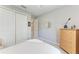 Bright bedroom with white walls, a round mirror, carpet floors, and double door closet at 204 Maraviya Blvd, Nokomis, FL 34275