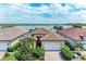 Beautiful waterfront home with lush landscaping, brick driveway, and two car garage at 204 Maraviya Blvd, Nokomis, FL 34275