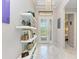 Elegant foyer with a decorative chandelier, white tile flooring, and stylish display shelves at 204 Maraviya Blvd, Nokomis, FL 34275