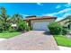 Inviting home exterior showcasing a brick driveway, two-car garage, and neatly maintained landscaping at 204 Maraviya Blvd, Nokomis, FL 34275