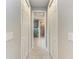 Hallway leading to bathroom, featuring tile flooring, and white doors to storage closets at 204 Maraviya Blvd, Nokomis, FL 34275