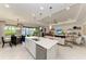 Open-concept kitchen with white quartz island and stainless steel appliances overlooking dining and living areas at 204 Maraviya Blvd, Nokomis, FL 34275
