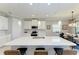 Kitchen island features white counters, stainless steel sink, pendant lighting, and seating for three at 204 Maraviya Blvd, Nokomis, FL 34275