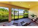 Screened lanai with lounge seating, brick pavers, and views of the water and landscaping at 204 Maraviya Blvd, Nokomis, FL 34275
