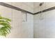 Close-up of the shower with a tiled feature stripe, tiled niche, and shower head at 204 Maraviya Blvd, Nokomis, FL 34275
