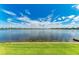 Wide water view of the community lake with lush green lawn and dock at 204 Maraviya Blvd, Nokomis, FL 34275