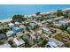 An aerial view captures a beachside community with colorful homes near the ocean at 2213 Avenue C, Bradenton Beach, FL 34217