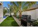 Landscaped backyard with artificial grass and patio, perfect for entertaining and relaxation at 2213 Avenue C, Bradenton Beach, FL 34217