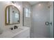 Bright bathroom with a modern vanity, arch mirror, and shower boasting designer patterned tile at 2213 Avenue C, Bradenton Beach, FL 34217