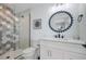 Modern bathroom featuring a shower with eye-catching tile, a stylish vanity, and decorative round mirror at 2213 Avenue C, Bradenton Beach, FL 34217