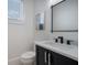 Modern half bathroom with a dark vanity, marble countertop, and sleek fixtures at 2213 Avenue C, Bradenton Beach, FL 34217