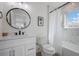 Chic bathroom with marble shower, white vanity, and round mirror at 2213 Avenue C, Bradenton Beach, FL 34217