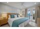 Bright bedroom featuring a ceiling fan, balcony access, and a stylish headboard at 2213 Avenue C, Bradenton Beach, FL 34217