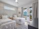 Bright bedroom featuring two twin beds, white accents, and french doors with a balcony view at 2213 Avenue C, Bradenton Beach, FL 34217
