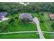Aerial view of home showing lush backyard landscaping, mature trees, and paver driveway at 22343 Panther Loop, Bradenton, FL 34202