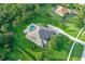 Aerial view of home featuring large manicured lawn, pool, garden, and brick driveway at 22343 Panther Loop, Bradenton, FL 34202