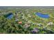 Overhead view of a home surrounded by lush landscape, mature trees, and a serene lake at 22343 Panther Loop, Bradenton, FL 34202