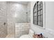 Bathroom featuring white subway tiled shower and toilet with decorative arch window mirror at 22343 Panther Loop, Bradenton, FL 34202