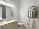 A well-lit half-bathroom features a vanity with natural stone countertops and a decorative, rustic mirror at 22343 Panther Loop, Bradenton, FL 34202