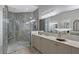 This bathroom features a walk-in shower with decorative tile and a double vanity with a decorative accent piece at 22343 Panther Loop, Bradenton, FL 34202
