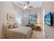 Bright bedroom boasting a ceiling fan and a large window with plantation shutters at 22343 Panther Loop, Bradenton, FL 34202